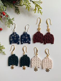 six pairs of knitted sweater earrings with snowflakes hanging from them