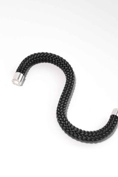 a black braided cord on a white background with the end plugged into it