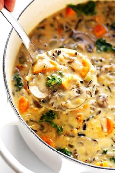 a ladle full of mushroom soup with carrots and broccoli