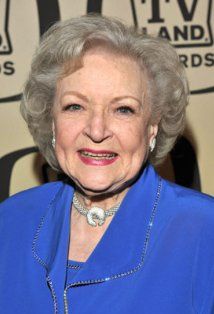 an older woman wearing a blue jacket and smiling