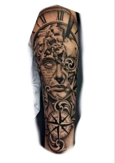 a man's arm with a clock, compass and face tattoo on the sleeve