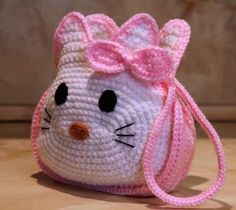 a crocheted hello kitty purse with a pink bow