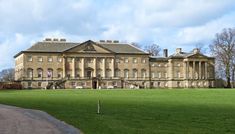 the large building has many windows on it's sides and is surrounded by green grass