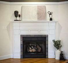 a living room with a fire place and a painting on the mantle