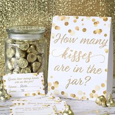 some gold confetti in a glass jar next to a sign that says how many kisses are in the jar?