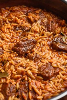 a pot filled with meat and rice on top of a wooden table