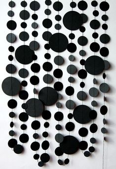 a black and white wall hanging made out of circular discs with string attached to it