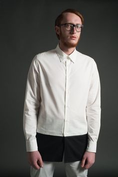 An elongated tunic shirt with black and white color block design by ARIEL BASSAN.ARIEL BASSAN is a sophisticated and contemporary menswear brand, that offers a unique and fresh high quality garments with a distinct signature of modern minimalism.This shirt is made out of a 100% Cotton, Crisp Woven Fabric. It has a contrasted hem panel with a ribbed tape detail.The extremely modern longline silhouette, with a longer back hem, will give you a slim and elongated sophisticated look.Model's height is Modern Semi-formal Spring Dress Shirt, Modern Slim Fit Top For Semi-formal Occasions, Modern White Dress Shirt For Semi-formal Occasions, Modern Semi-formal Shirt With Relaxed Fit, Modern Relaxed Fit Shirt For Semi-formal Occasions, Modern Slim Fit White Tops, Modern Slim Fit White Top, Modern White Slim Fit Tops, Modern White Slim Fit Top