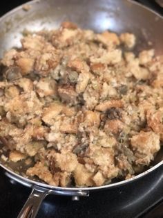 a pan filled with stuffing sitting on top of a stove