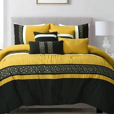 a bed with yellow and black comforters in a room