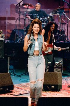 a woman standing on top of a stage holding a microphone