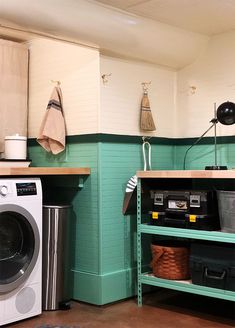 a washer and dryer in a small room with green paint on the walls