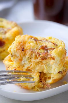 an egg muffin on a white plate with a fork sticking out of the middle