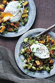 two plates filled with vegetables and an egg on top of each one, sitting on a table