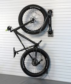 a bicycle mounted to the side of a garage wall with a bike hanging on it