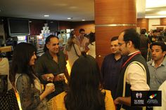 a group of people standing around each other in a room with food on the counter