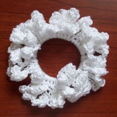 a white crocheted hair scrunffle on a wooden surface