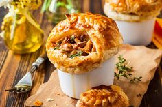 two pot pies sitting on top of a wooden cutting board