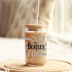 a drink in a jar with the beatles sticker on it sitting on a wooden coaster