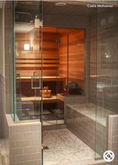 a glass enclosed sauna in the middle of a bathroom