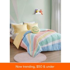 a child's bedroom with blue, yellow and pink striped comforter on the bed