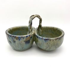 two ceramic bowls with handles on each side