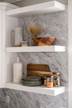 two white shelves with plates and bowls on them