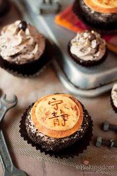 chocolate cupcakes with frosting and chinese characters on them are ready to be eaten