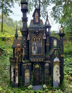 an elaborately designed house in the woods with lots of windows and decorations on it