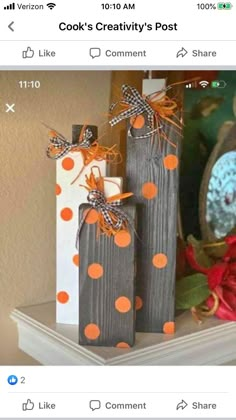 two wooden candles are sitting on top of a mantle with orange and white polka dots