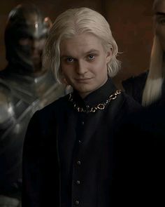 game of thrones character in black outfit with white hair and blonde hair standing next to two other characters