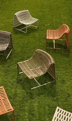 five different colored chairs sitting in the grass