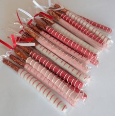 candy canes wrapped in clear cellophane and tied with red ribbon on white table