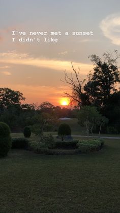 the sun is setting behind some trees and bushes in a park with an inspirational quote on it