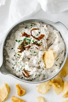 a metal bowl filled with dip and chips