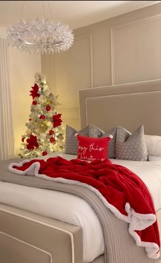 a christmas tree in the corner of a bedroom with red and white decorations on it