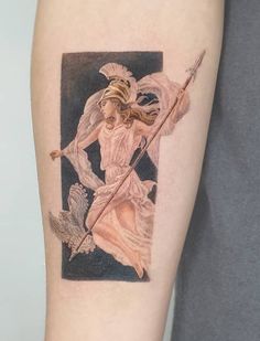 a woman with an angel tattoo on her arm holding a stick and arrow in one hand