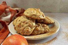 three cookies on a plate next to an apple