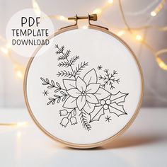 the embroidery pattern is being displayed in front of a christmas tree with lights behind it