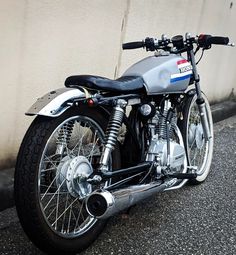 a silver motorcycle parked next to a wall