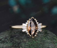 an oval shaped brown diamond ring on top of a rock