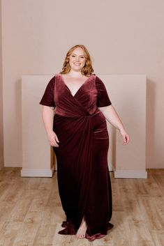 a woman in a brown dress standing on a wooden floor