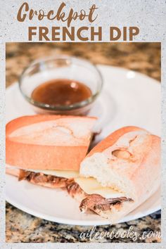 a sandwich on a plate with some dipping sauce in the bowl next to it, sitting on a marble counter top