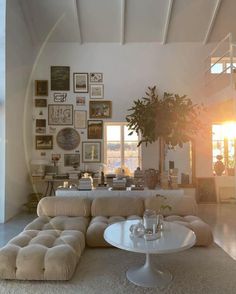 a living room filled with lots of furniture and pictures on the wall above it's windows