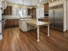 a large kitchen with wooden floors and cabinets