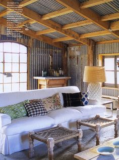 a living room filled with furniture and lots of wooden beams on the ceiling above it