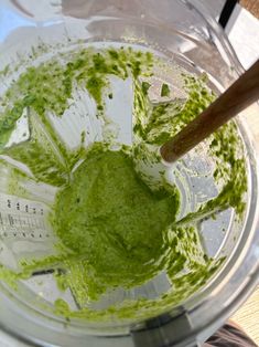 a blender filled with green liquid on top of a table