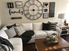 a living room with white couches and black and white decor on the wall above them