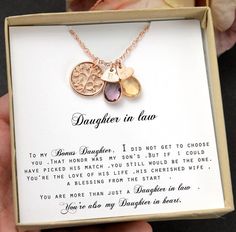 a person holding up a box with two necklaces in it's hand and the words open your en message card written below