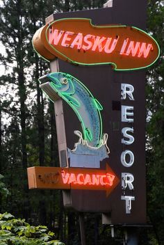 a neon sign for a resort with a fish on it's head and the words, weasku inn resort